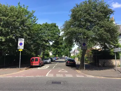 a street with cars parked on the side of the road at Scotstoun Appartments in Glasgow