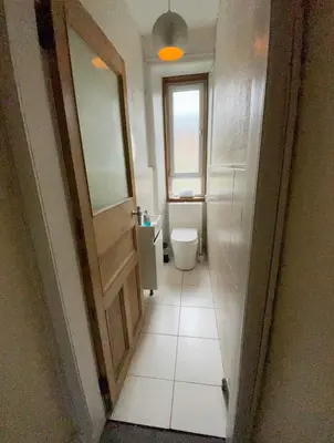 a small bathroom with a toilet and a window at Scotstoun Appartments in Glasgow
