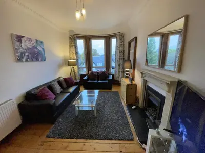 a living room with a couch and a fireplace at Scotstoun Appartments in Glasgow