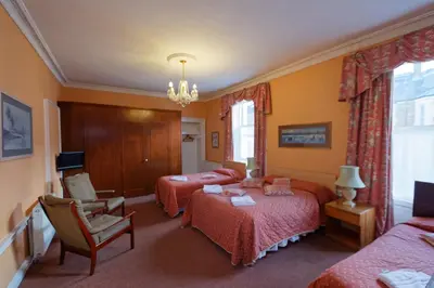 a hotel room with two beds and a chandelier at Averon Guest House in Edinburgh