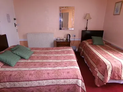 a hotel room with two beds and a mirror at Averon Guest House in Edinburgh