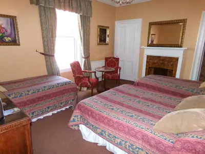 a hotel room with two beds and a fireplace at Averon Guest House in Edinburgh