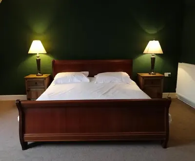 a bedroom with a large bed with two lamps on both sides at Broomhall Castle Hotel in Stirling