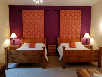 two beds in a room with purple walls at Broomhall Castle Hotel in Stirling