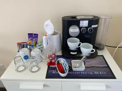 a table with a coffee maker and cups on it at The Bowmore House Bed and Breakfast in Bowmore