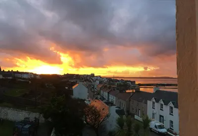 a view of a city with the sunset in the background at The Bowmore House Bed and Breakfast in Bowmore