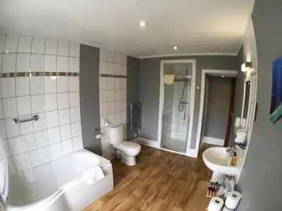 a bathroom with a tub and a toilet and a sink at The Bowmore House Bed and Breakfast in Bowmore