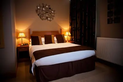 a bedroom with a large bed and two lamps at The City Hotel in Dunfermline