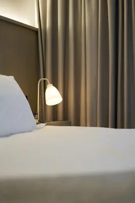 a bedroom with a bed with a lamp and a curtain at Rabble in Edinburgh