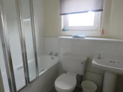 a bathroom with a toilet and a shower and a sink at Cunninghame 1 in Beith