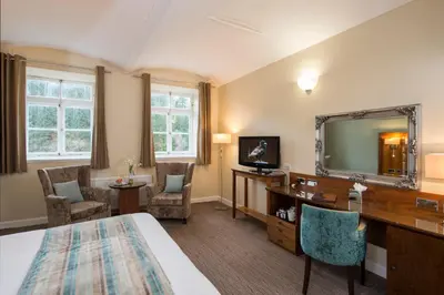 a hotel room with a bed and a desk and a mirror at New Lanark Mill Hotel in Lanark