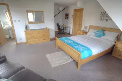 a bedroom with a large bed and a desk at ArdFyne on Lochfyne in Strachur