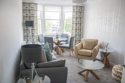 a living room with chairs and a couch and a table at Lexington Apartments in Rothesay