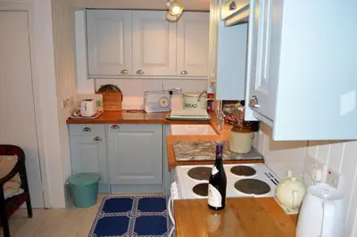 a kitchen with a bottle of wine on a counter at Newton Cottage North in Inveraray