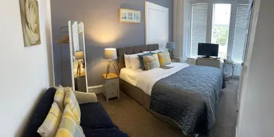 a bedroom with a bed and a television in it at Haylie Hotel in Largs