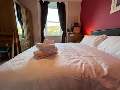a bedroom with a large white bed with a window at The waterfront in Tarbert