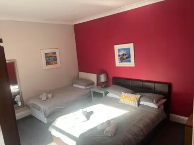 a room with two beds and a red wall at The waterfront in Tarbert