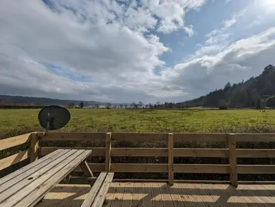 a wooden bench sitting on top of a field at The Manor Sea View 8 in Dunoon