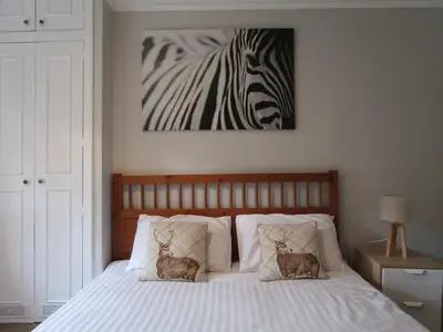 a bedroom with a bed with a zebra picture on the wall at Westend Glasgow Apartment in Glasgow