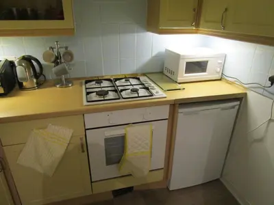 a kitchen with a stove top oven next to a microwave at Westend Glasgow Apartment in Glasgow