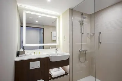 a bathroom with a sink and a shower with a mirror at Courtyard by Marriott Edinburgh West in Edinburgh