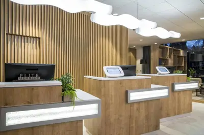 a lobby with three counters with computers on them at Courtyard by Marriott Edinburgh West in Edinburgh