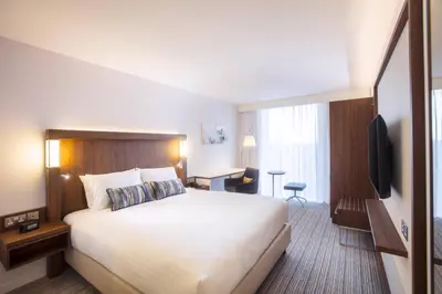 a hotel room with a bed and a television at Courtyard by Marriott Edinburgh West in Edinburgh
