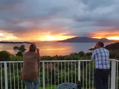 a man and a woman taking a picture of the sunset at Appin Bay View in Appin