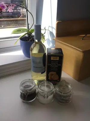 a bottle of wine sitting next to two glass jars at 1/5 Lismore House in Oban