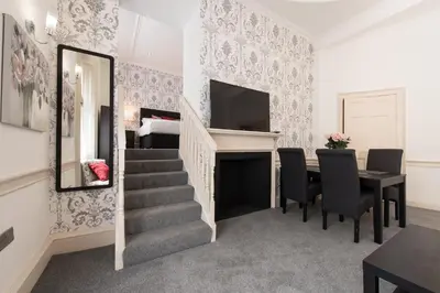 a dining room with a staircase and a table and chairs at Royal Princes Suites in Edinburgh