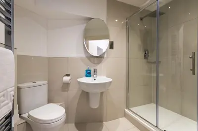 a bathroom with a toilet and a sink and a shower at Royal Princes Suites in Edinburgh