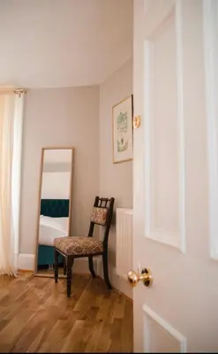 a bedroom with a chair and a mirror at Georgian House in Edinburgh