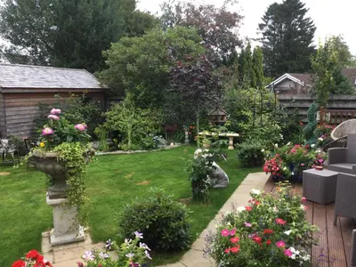 a garden with flowers and a wooden fence at Angel Cottage in Drymen