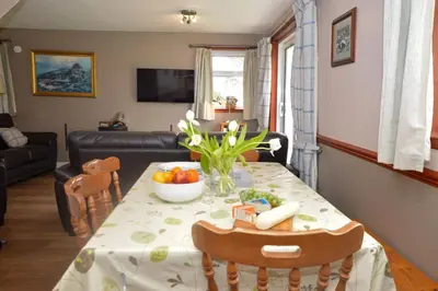a living room with a table with a bowl of fruit at Birch Cottage in Blairmore