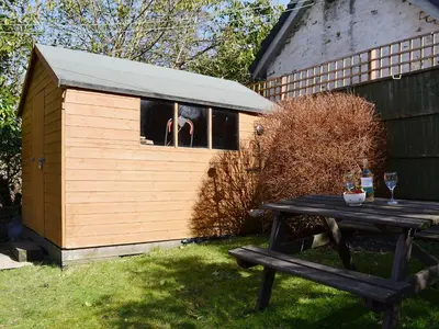 a dog sticking its head out of a window in a dog house at Craigdarroch Cottage in Strathyre