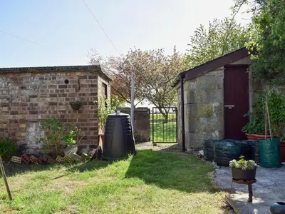 a backyard with a brick building and a fence at Sandhaven in Culross