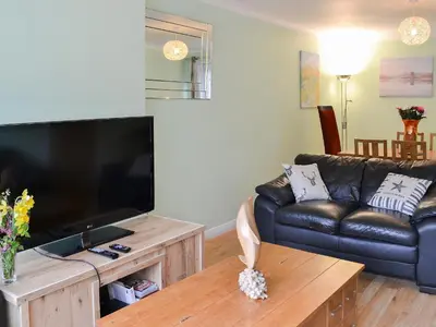a living room with a couch and a large television at Harbour View in Oban