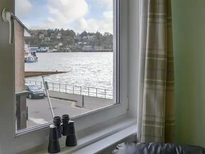a window with a view of a body of water at Harbour View in Oban