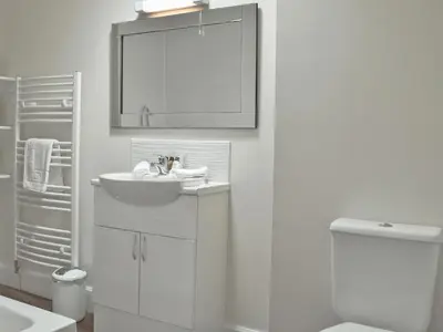 a white bathroom with a sink and a toilet at Casa Duran in Killin