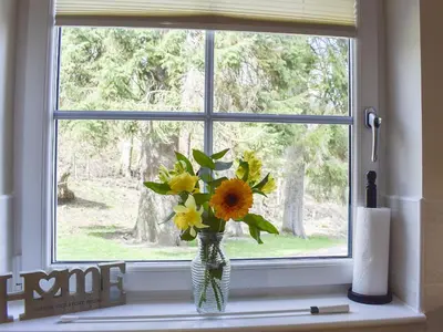a vase of flowers sitting on a window sill at Casa Duran in Killin