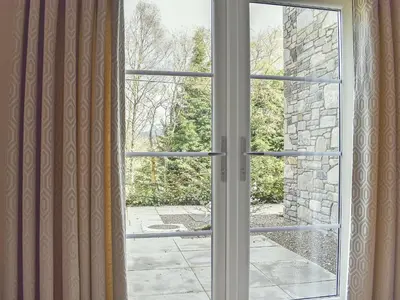 an open window with a view of a stone wall at Casa Duran in Killin