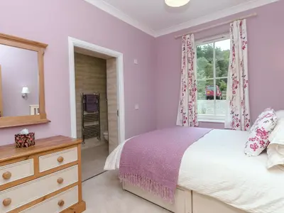 a bedroom with a bed and a window at Grace's Cottage in Port of Menteith