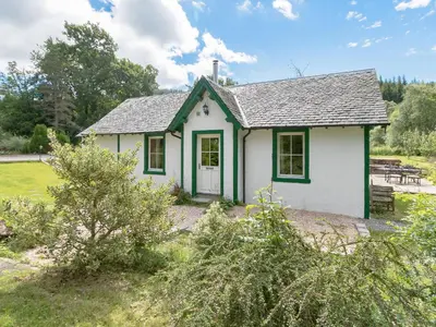 a small white house with a green roof at Grace's Cottage in Port of Menteith