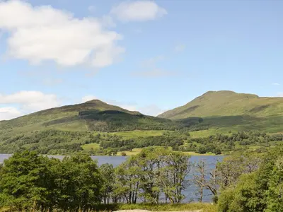 a view of a lake with mountains in the background at Grace's Cottage in Port of Menteith