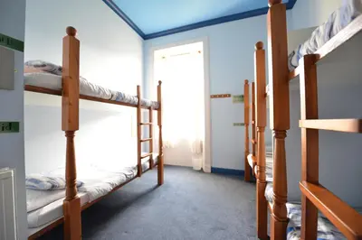 a room with four bunk beds and a window at Oban Backpackers in Oban