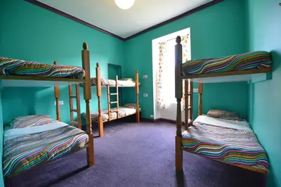 a room with three bunk beds and a window at Oban Backpackers in Oban