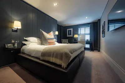 a bedroom with a large bed with pillows on it at Dakota Eurocentral in Motherwell
