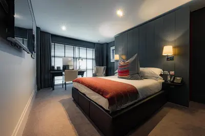 a bedroom with a large bed with a black headboard at Dakota Eurocentral in Motherwell