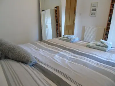 a bed in a room with towels on it at Snug - Krayr Apartment in Helensburgh