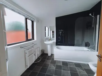 a bathroom with a white tub and a sink at The Old Dairy in Brodick